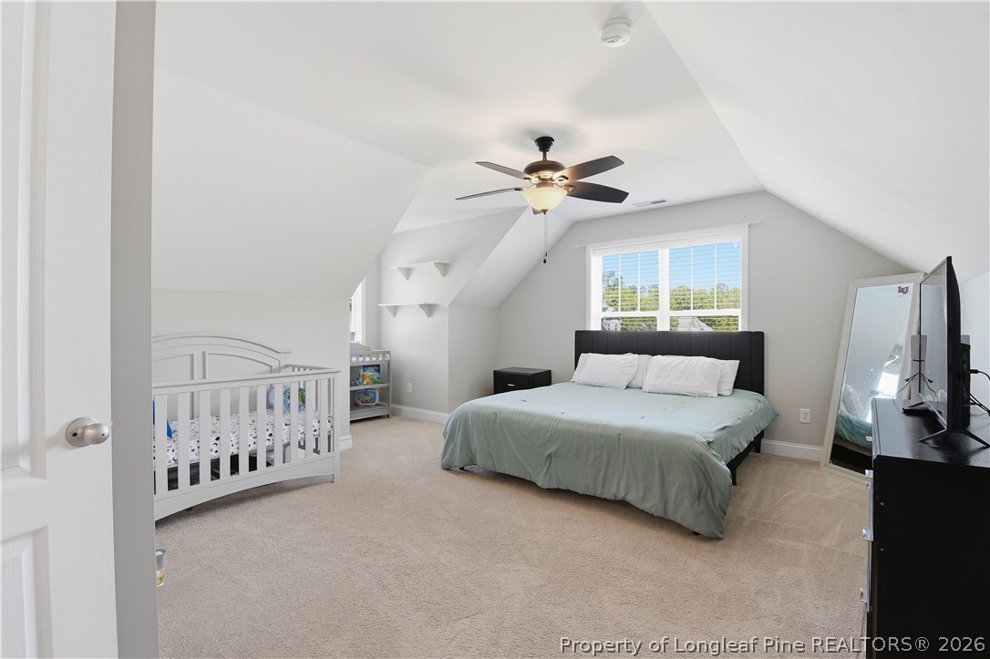 140 Birch Avenue Spring Lake, NC 28390 - Photo 40 of 49 a spacious bedroom with a bed a chandelier and dresser