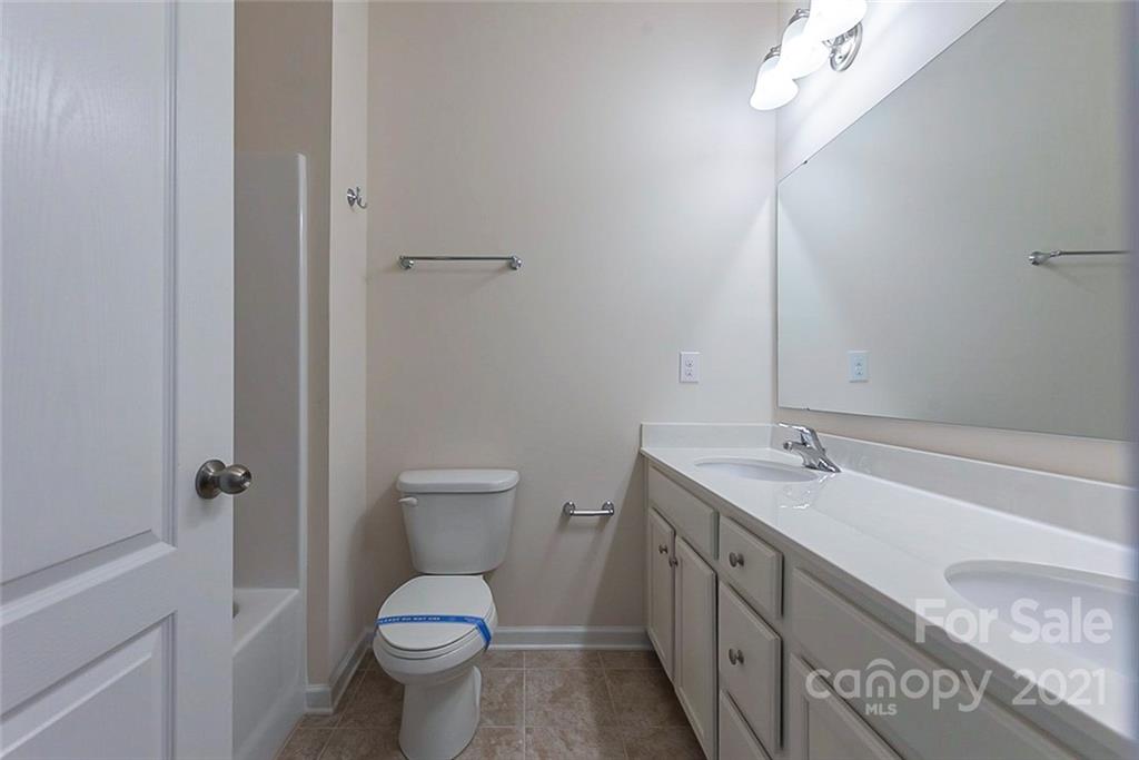 541 Dulaney Drive Fort Mill, SC 29708 - Photo 13 of 16 a bathroom with a granite countertop toilet a sink and a mirror