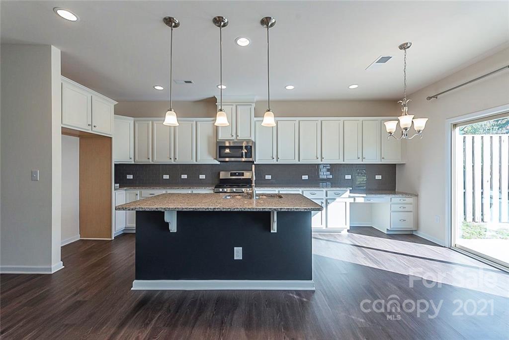 541 Dulaney Drive Fort Mill, SC 29708 - Photo 4 of 16 a kitchen with kitchen island granite countertop a sink cabinets and wooden floor