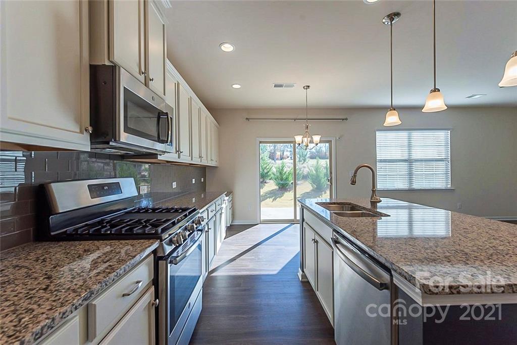 541 Dulaney Drive Fort Mill, SC 29708 - Photo 8 of 16 a kitchen with stainless steel appliances granite countertop a stove a sink and a wooden cabinets