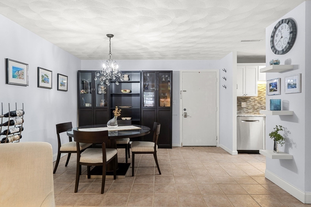 7 Greenbriar Drive, Unit 304 North Reading, MA 01864 - Photo 11 of 23 a view of a dining room with furniture and a chandelier