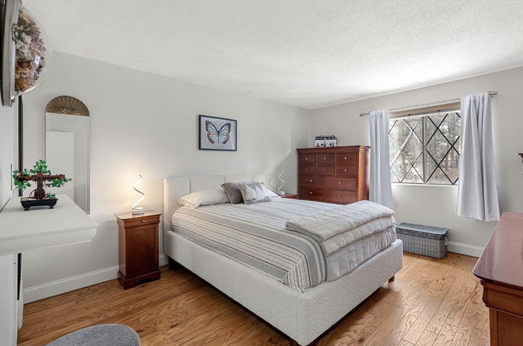 7 Greenbriar Drive, Unit 304 North Reading, MA 01864 - Photo 15 of 23 a bedroom with a bed and a painting on the wall