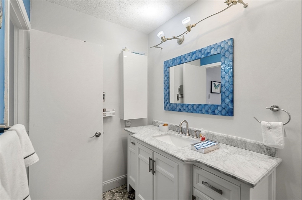 7 Greenbriar Drive, Unit 304 North Reading, MA 01864 - Photo 18 of 23 a bathroom with a granite countertop sink and a mirror