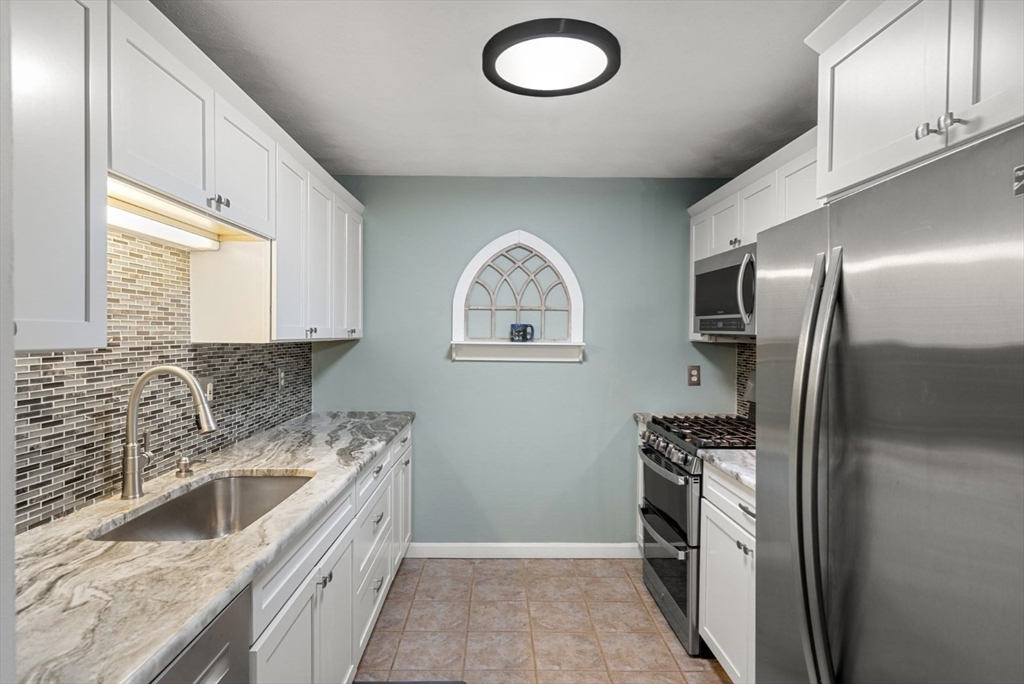 7 Greenbriar Drive, Unit 304 North Reading, MA 01864 - Photo 6 of 23 a kitchen with stainless steel appliances granite countertop a refrigerator a sink and a stove
