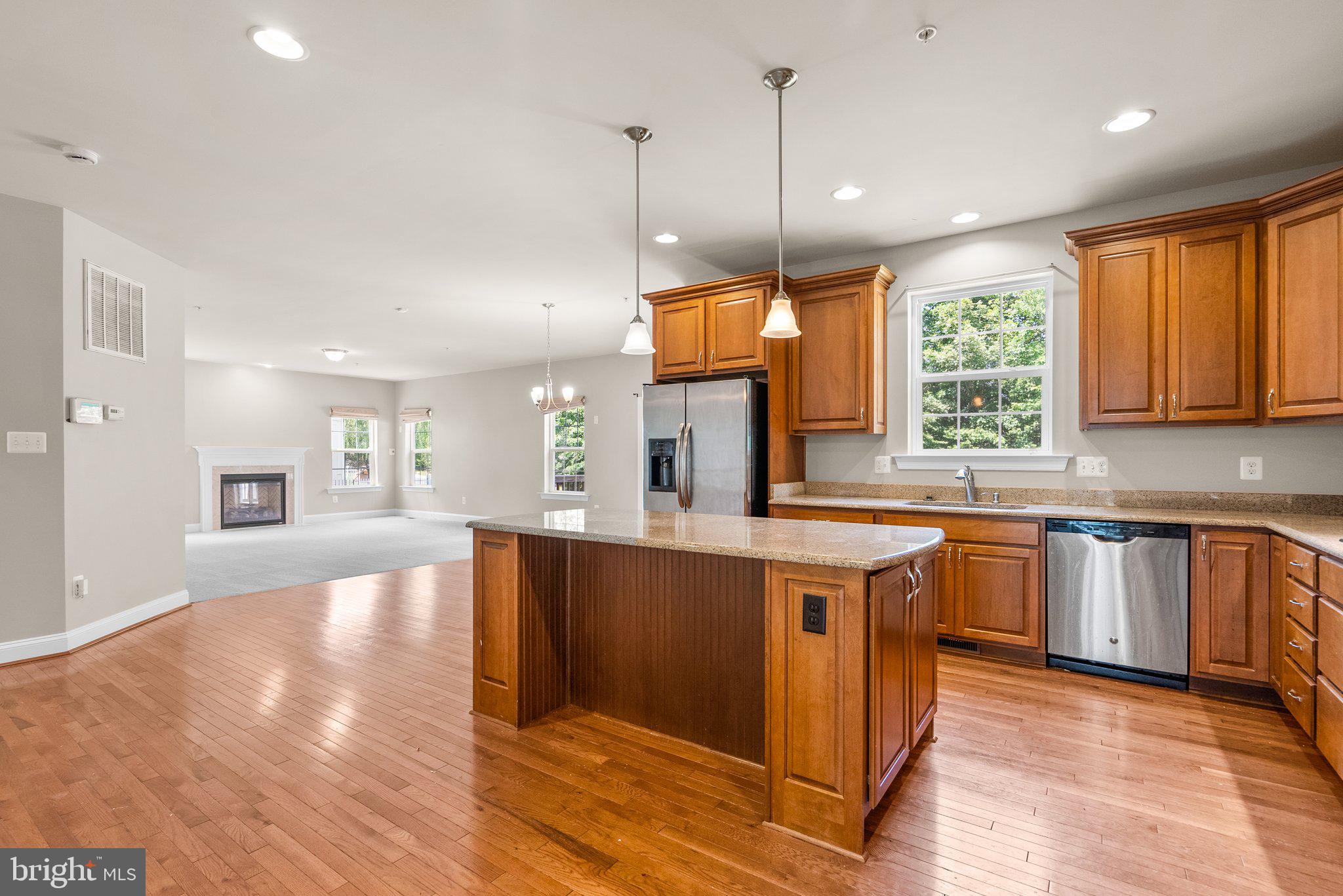 9602 Pep Rally Lane Waldorf, MD 20603 - Photo 13 of 44 a large kitchen with stainless steel appliances granite countertop a stove a sink dishwasher and a large refrigerator with wooden floor