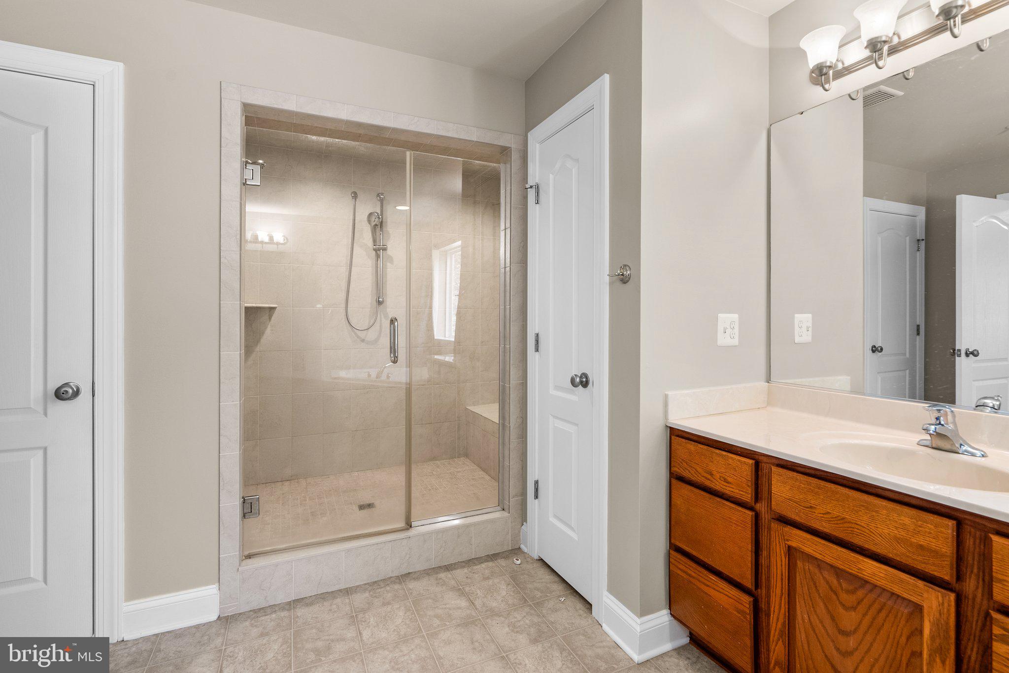 9602 Pep Rally Lane Waldorf, MD 20603 - Photo 25 of 44 a bathroom with a shower sink vanity and mirror
