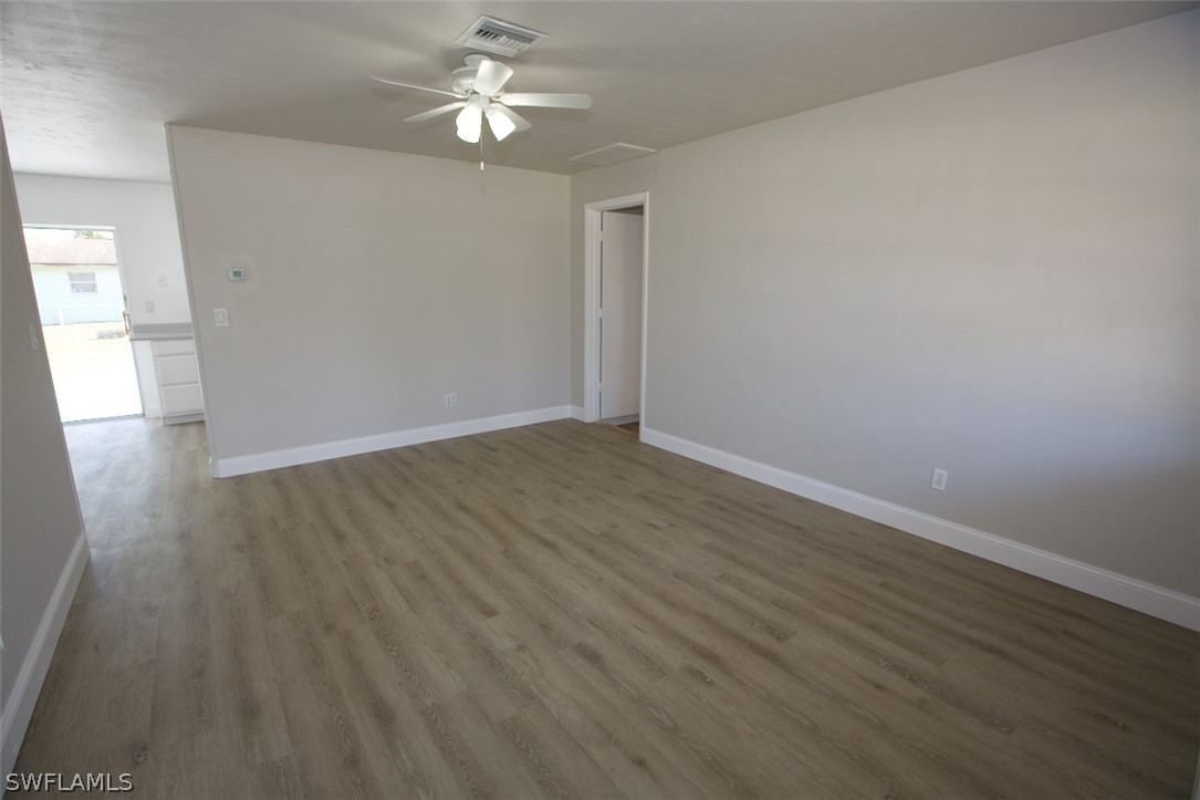 9196 Hamlin Road East Fort Myers, FL 33967 - Photo 3 of 19 wooden floor in an empty room with a window