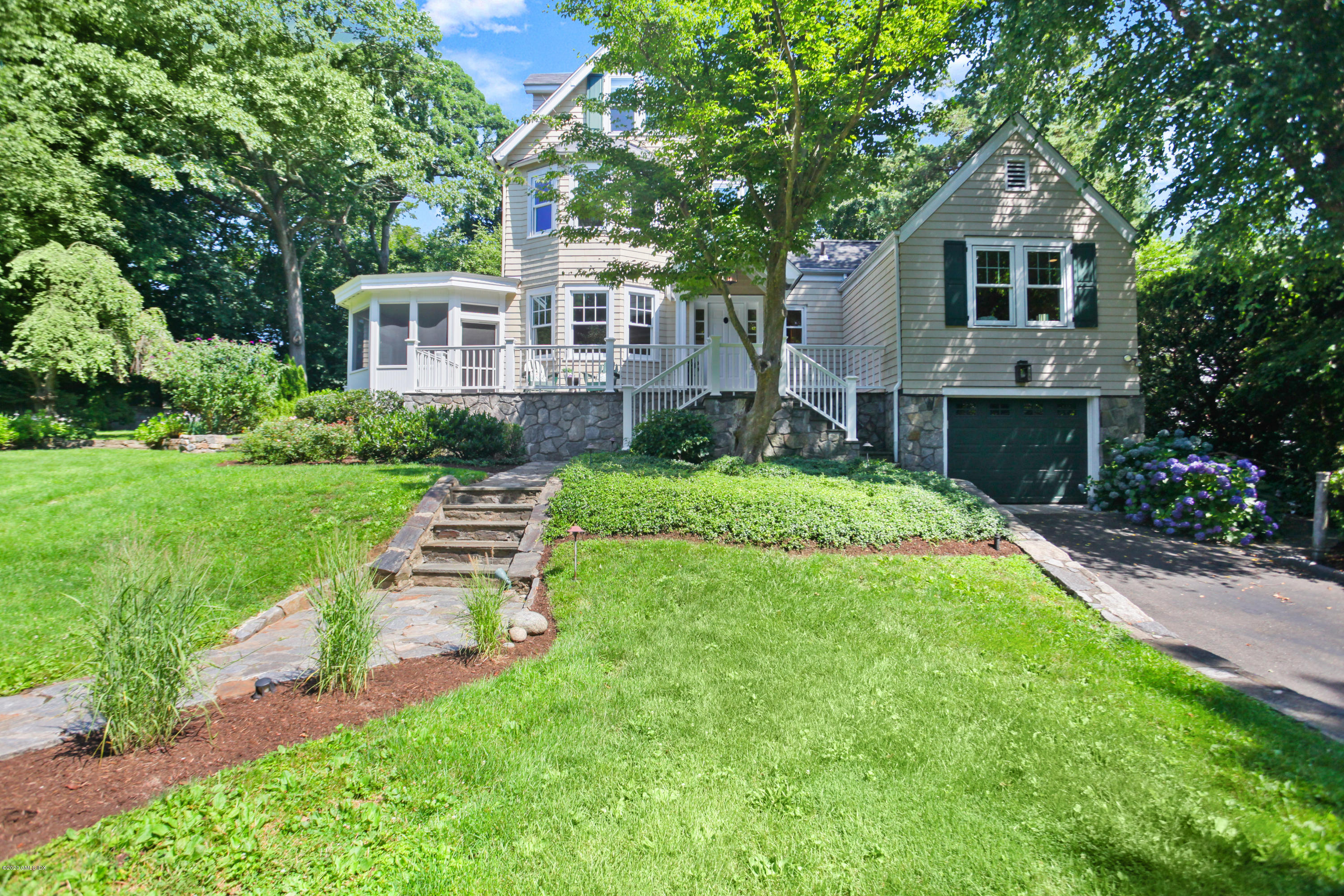 a front view of a house with yard and green space