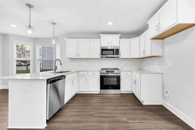 a kitchen with stainless steel appliances granite countertop a stove sink and cabinets