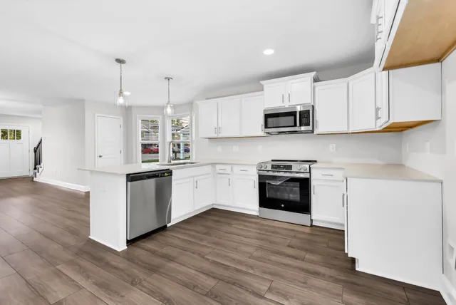 a kitchen with granite countertop white cabinets and white appliances