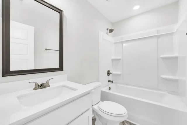 a bathroom with a sink toilet vanity and bathtub