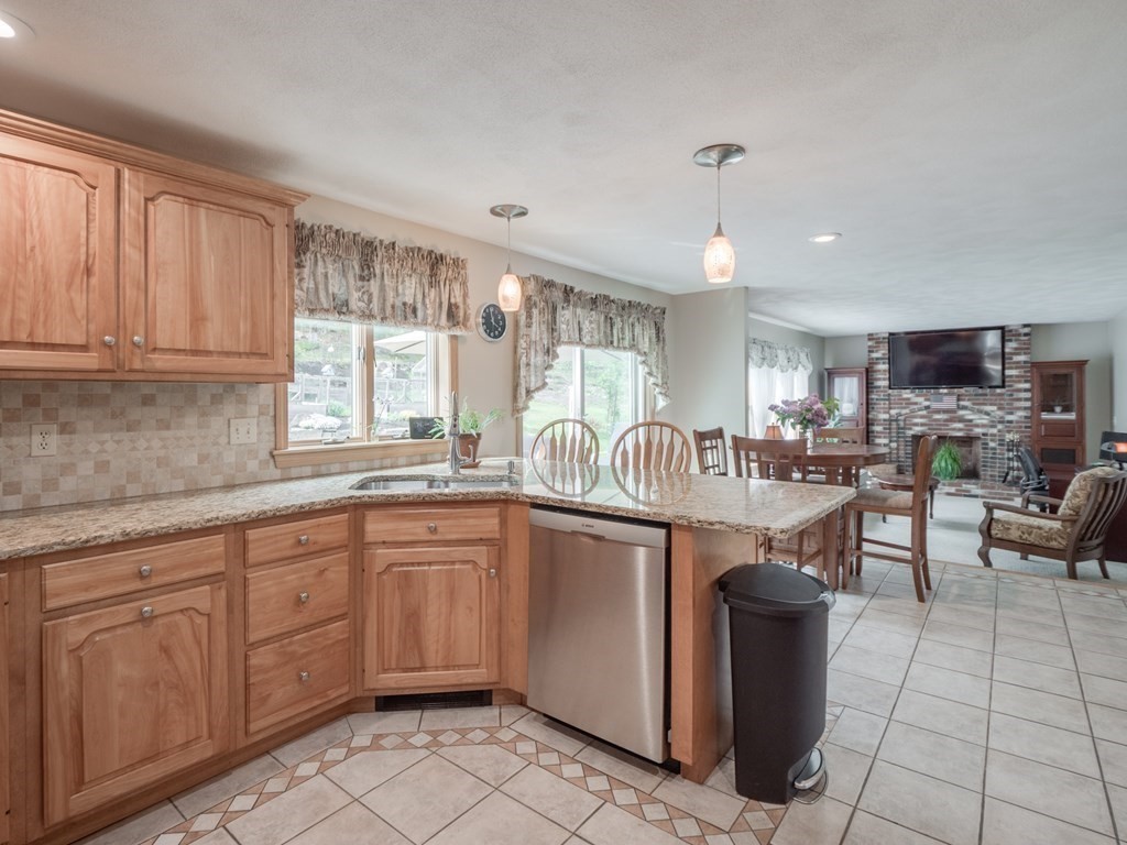 21 Scenic View Drive Pelham, NH 03076 - Photo 16 of 42 a large kitchen with kitchen island granite countertop a stove a sink dishwasher and white cabinets with wooden floor
