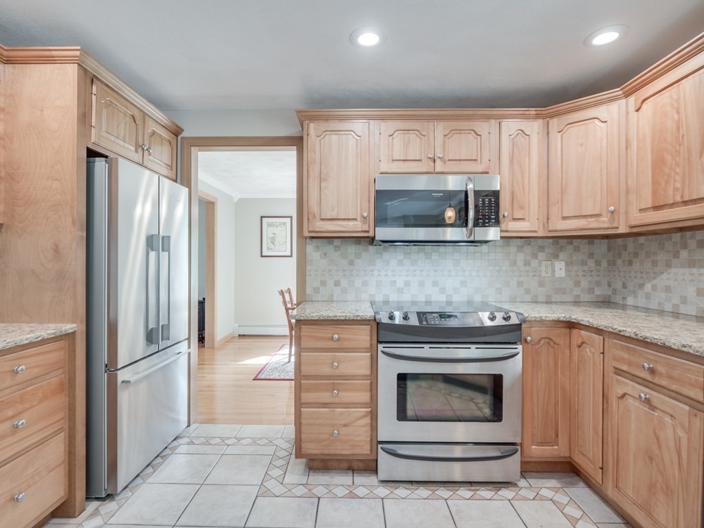 21 Scenic View Drive Pelham, NH 03076 - Photo 19 of 42 a kitchen with granite countertop a stove microwave and refrigerator
