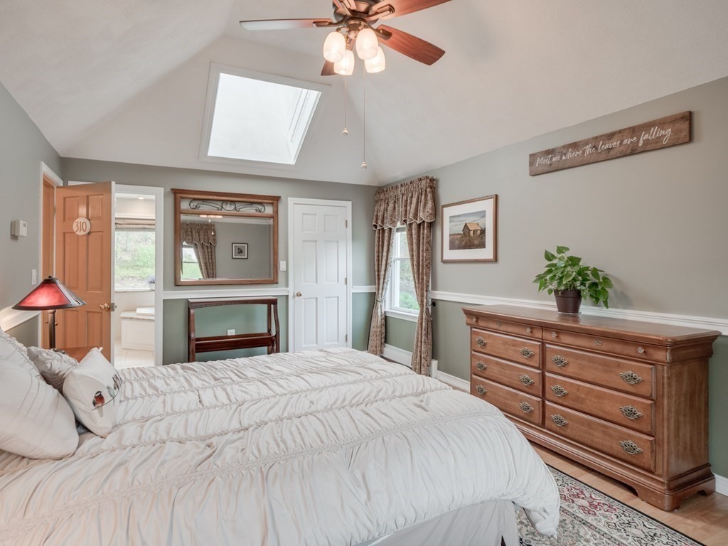 21 Scenic View Drive Pelham, NH 03076 - Photo 34 of 42 a bedroom with a large bed and a chandelier