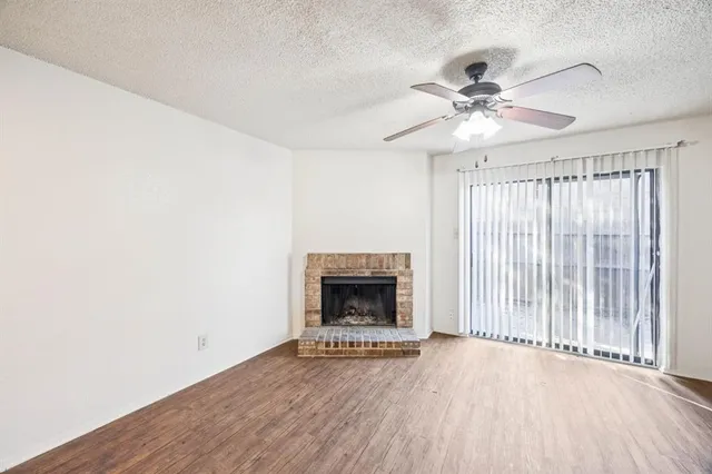 a view of an empty room with a fireplace and a window