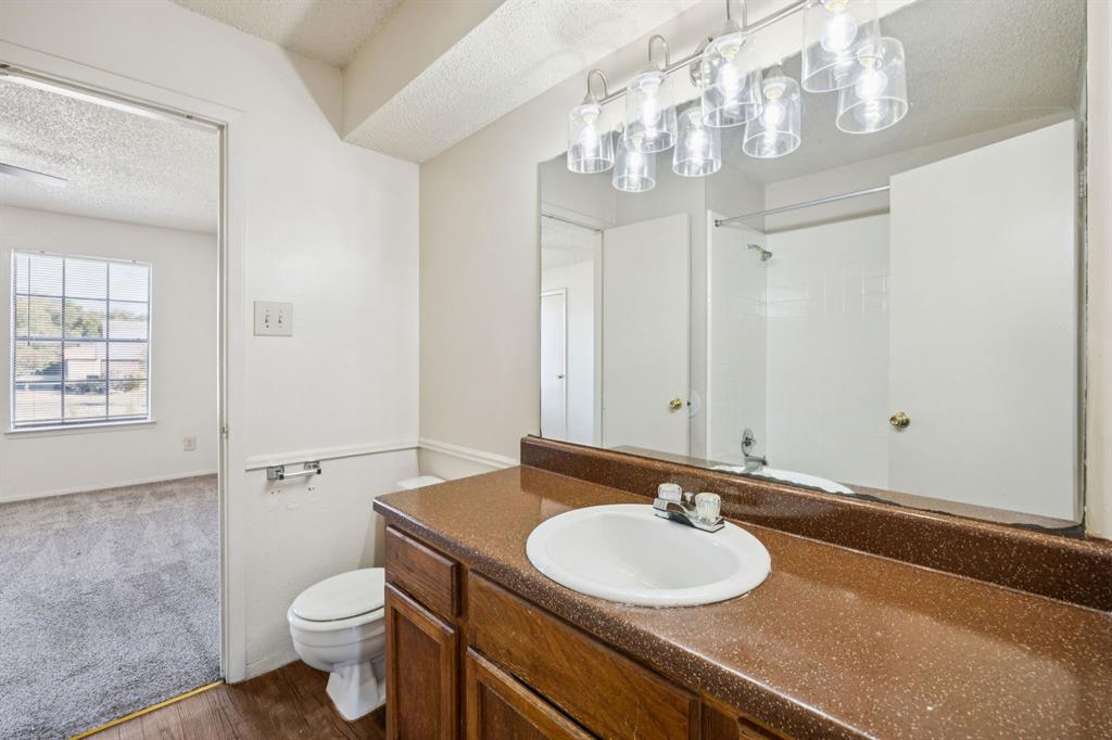 8109 Silver Creek Road, Unit B White Settlement, TX 76108 - Photo 18 of 28 a bathroom with a sink a toilet and a mirror