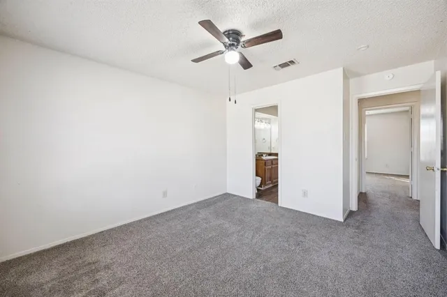 an empty room with closet and ceiling fan