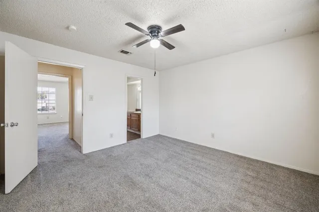 a view of an empty room with wooden floor fireplace and a window