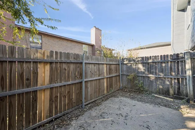a view of backyard with wooden fence