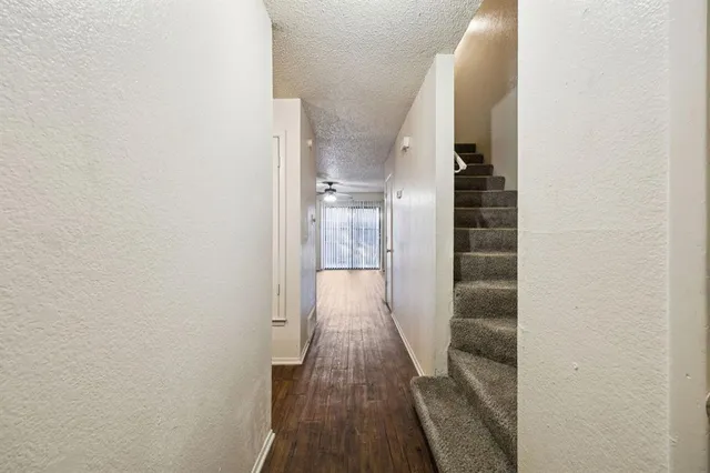 a view of a hallway with wooden floor and staircase