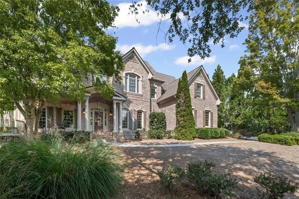 a front view of a house with a yard and trees