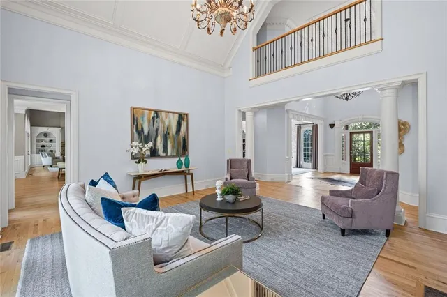 a kitchen with granite countertop a stove a sink a dining table and chairs with wooden floor