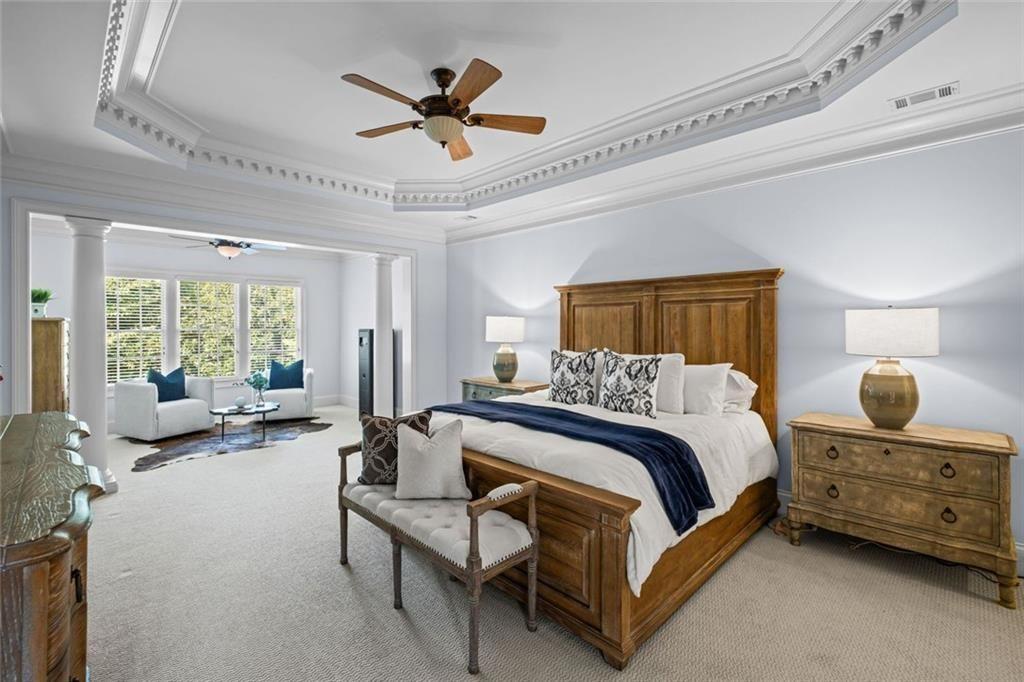 2281 Bransley Place Duluth, GA 30097 - Photo 31 of 70 a spacious bedroom with a bed a couch and a chandelier