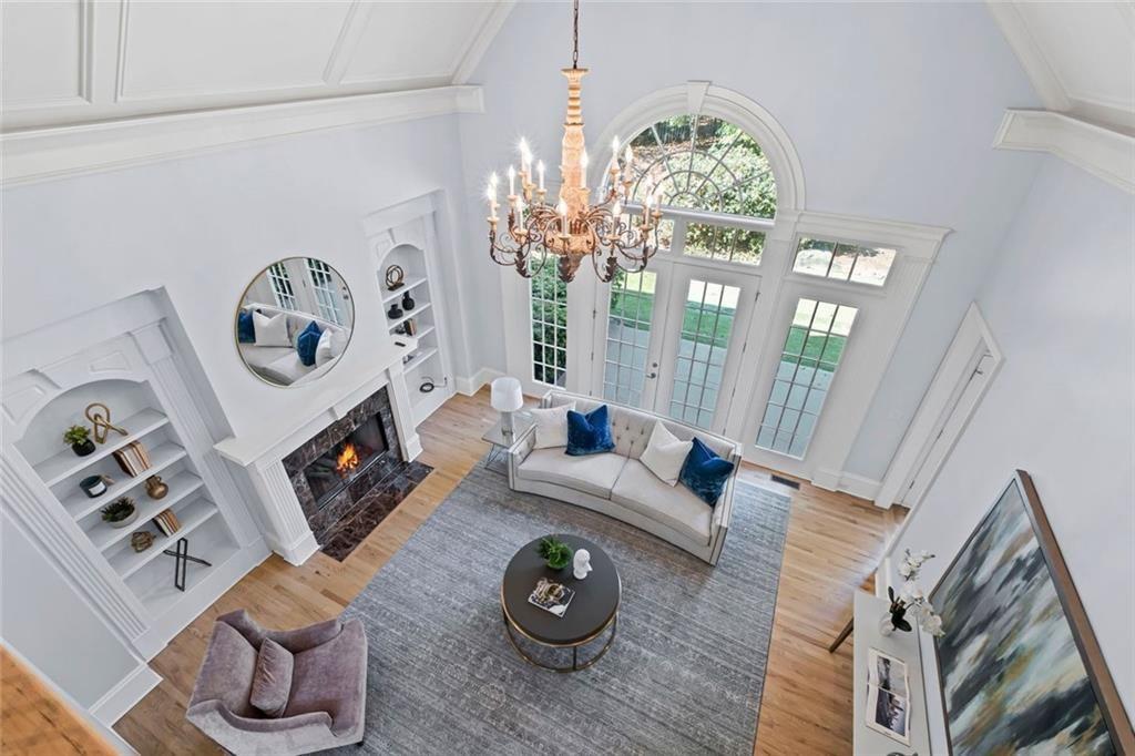 2281 Bransley Place Duluth, GA 30097 - Photo 42 of 70 a living room with furniture a fireplace and a chandelier