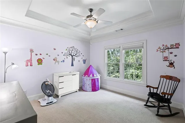 a view of a yard with plants and large trees