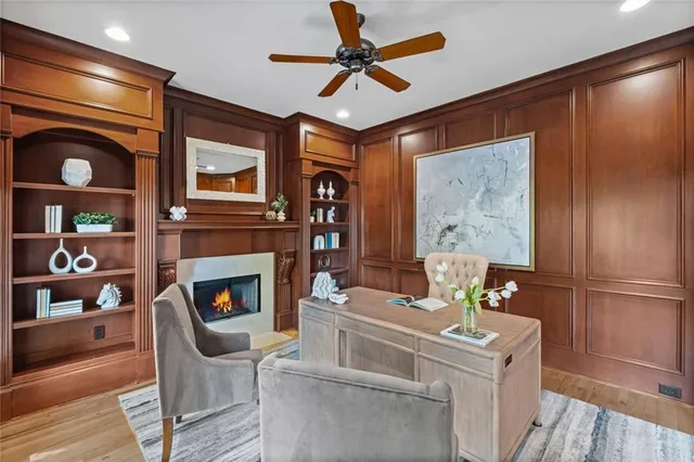 a living room with furniture fireplace and large windows