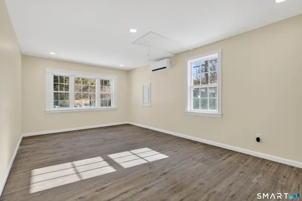 a view of an empty room with wooden floor and closet