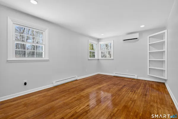 a view of empty room with wooden floor