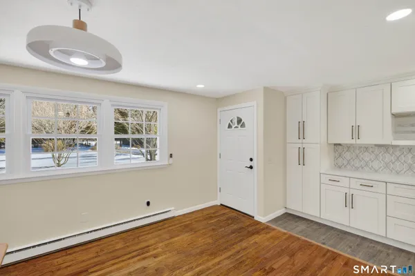 a view of a kitchen with wooden floor and a window