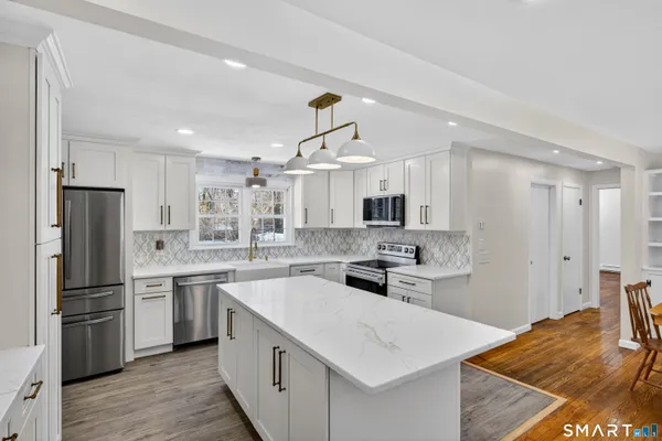 a kitchen with stainless steel appliances a refrigerator sink and microwave