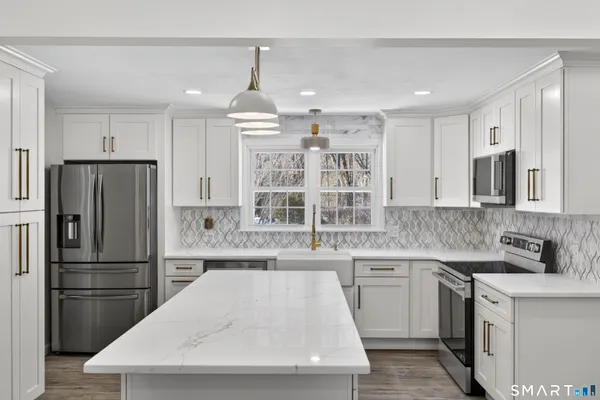 a kitchen with granite countertop a sink stove and cabinets