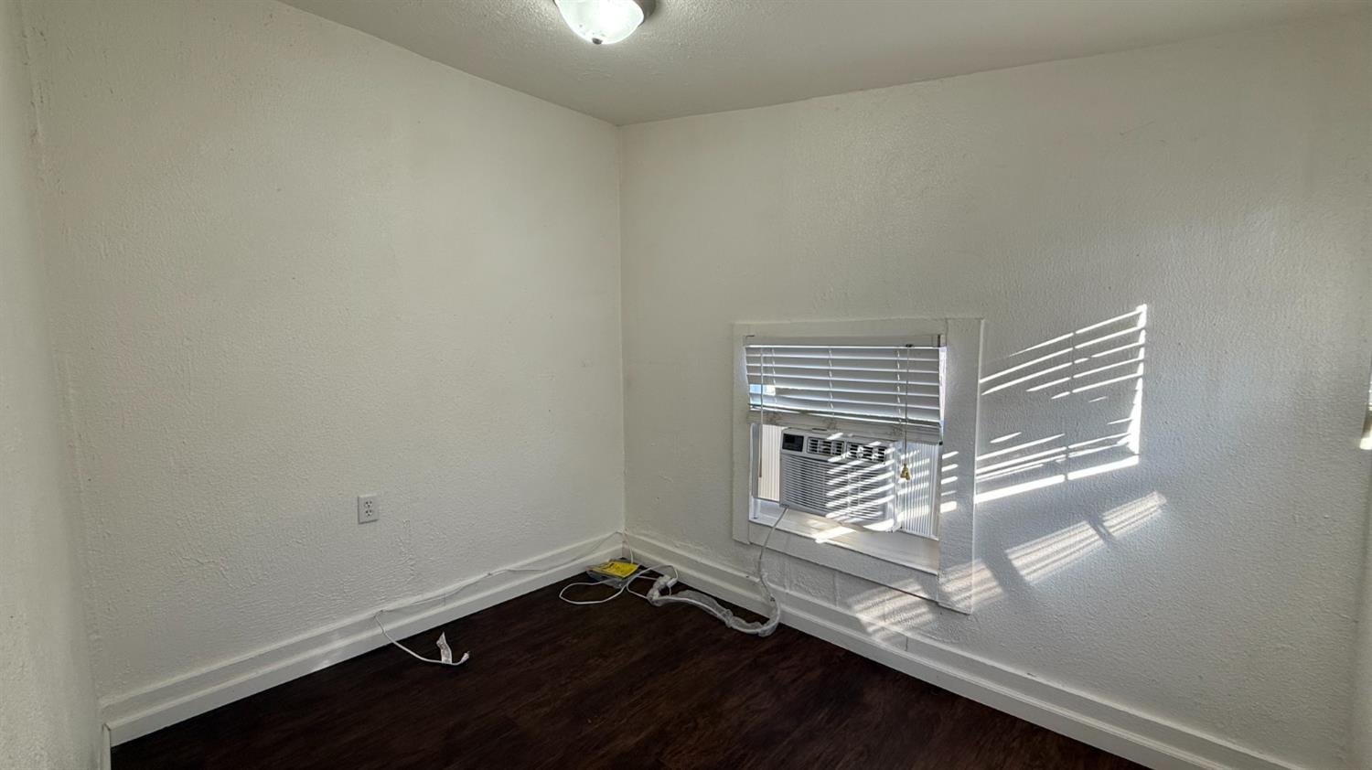 813 West 6th Street Hanford, CA 93230 - Photo 11 of 15 an empty room with a wooden floor