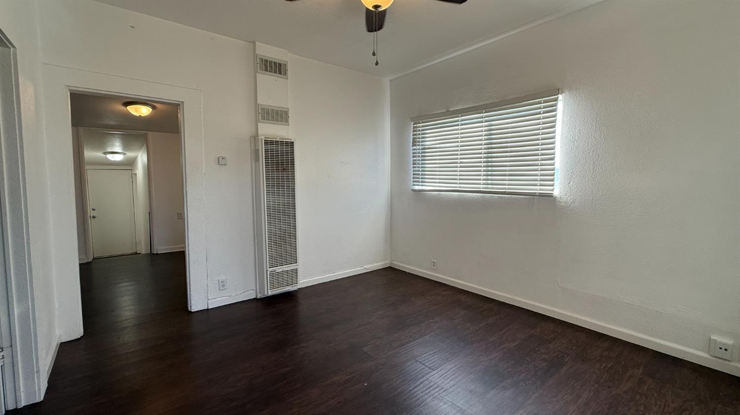 813 West 6th Street Hanford, CA 93230 - Photo 5 of 15 an empty room with wooden floor and windows