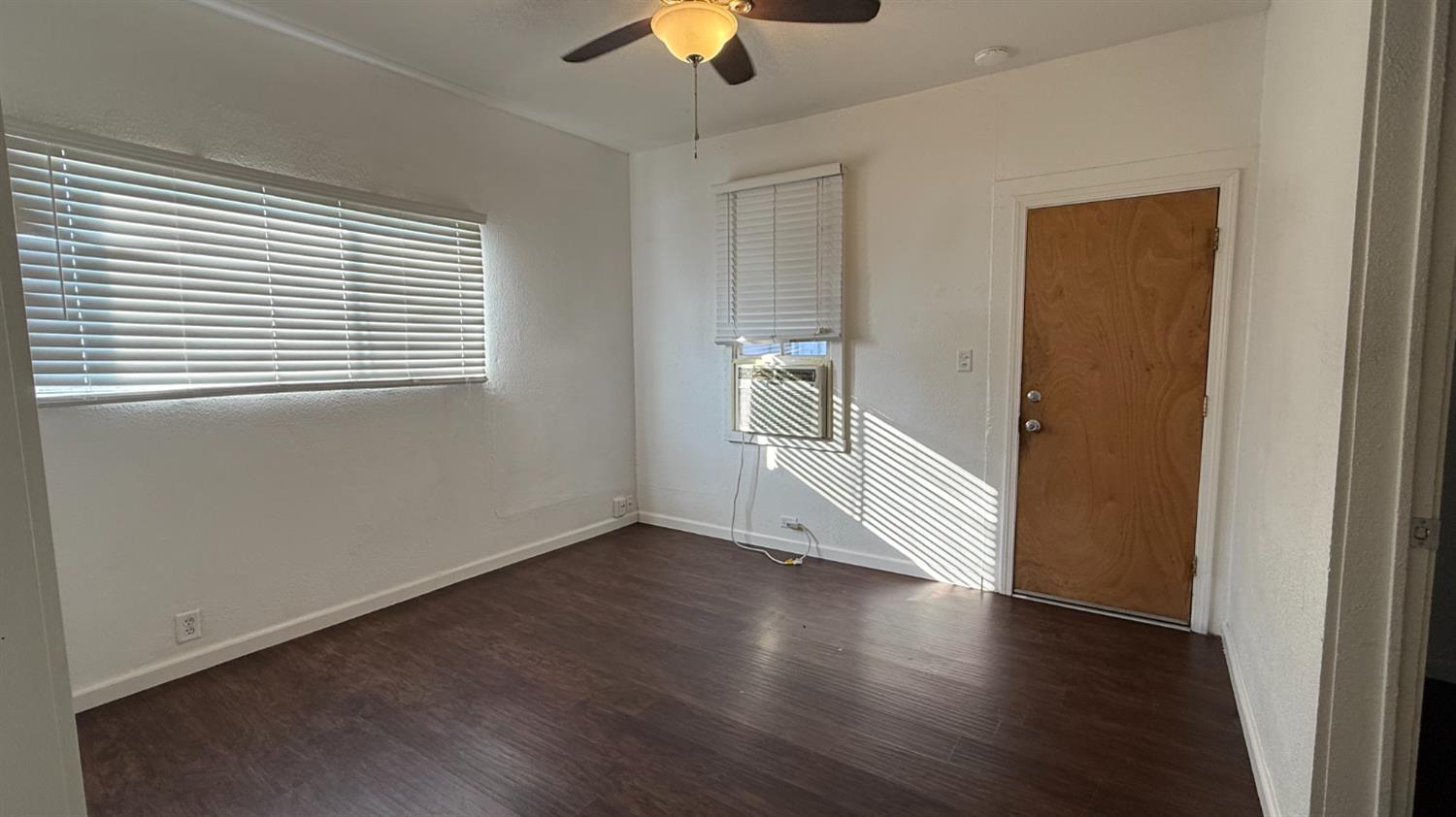 813 West 6th Street Hanford, CA 93230 - Photo 6 of 15 a view of an empty room with a window and wooden floor