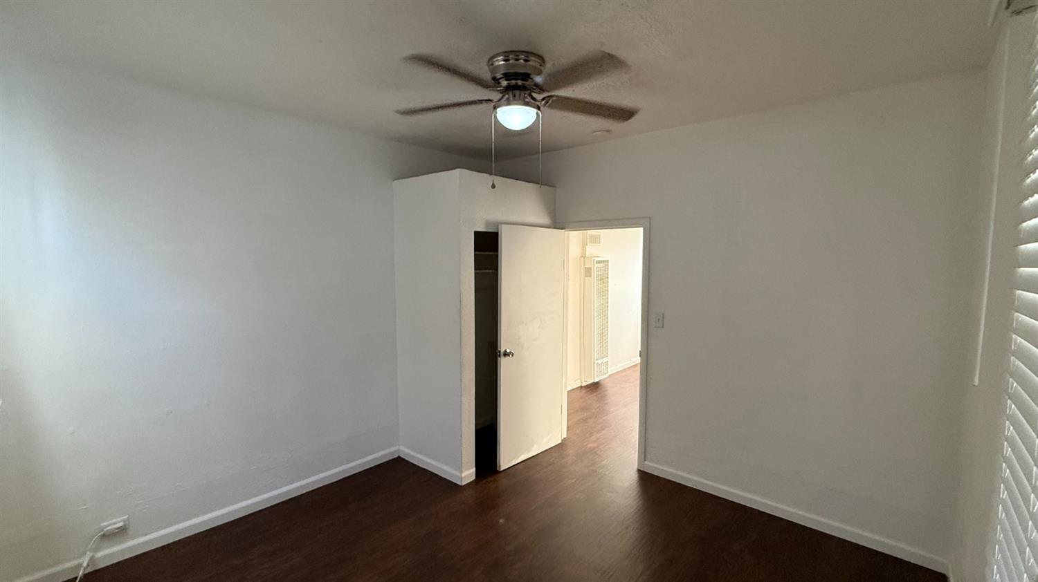813 West 6th Street Hanford, CA 93230 - Photo 8 of 15 an empty room with wooden floor and windows