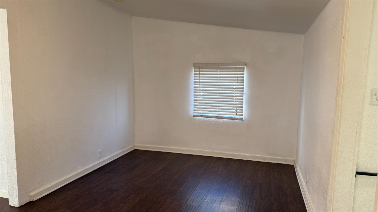 813 West 6th Street Hanford, CA 93230 - Photo 10 of 15 an empty room with wooden floor and windows