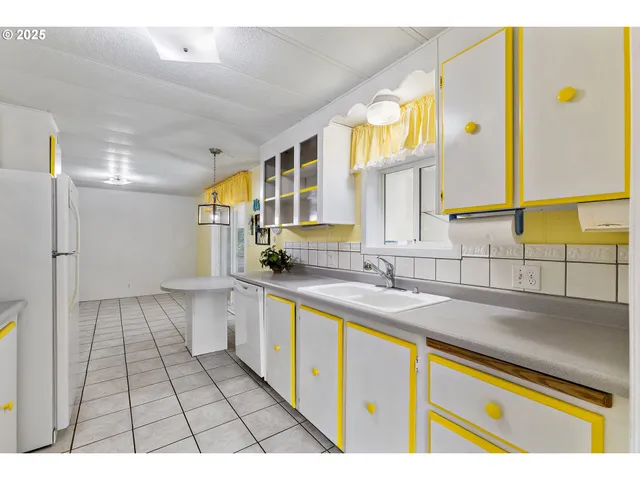 a open kitchen with stainless steel appliances granite countertop a sink and a white cabinets