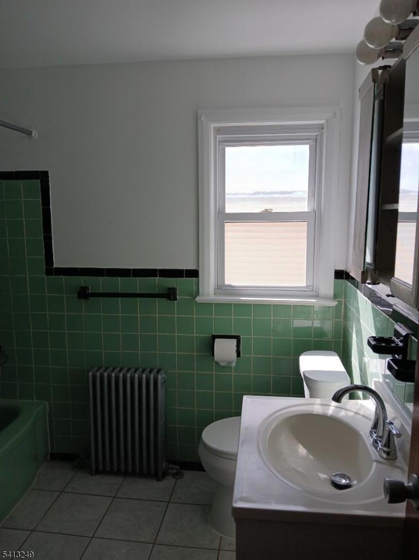 97 Main Avenue, Unit 2 Passaic, NJ 07055 - Photo 6 of 8 a bathroom with a sink toilet and window
