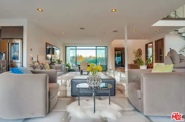 a living room with patio furniture and a floor to ceiling window