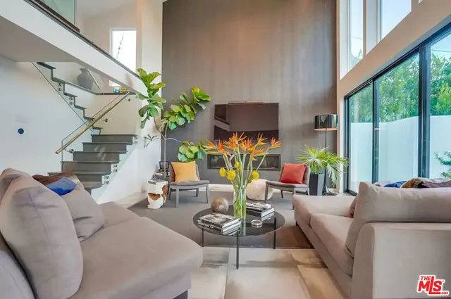 a living room with furniture flowers and a potted plant