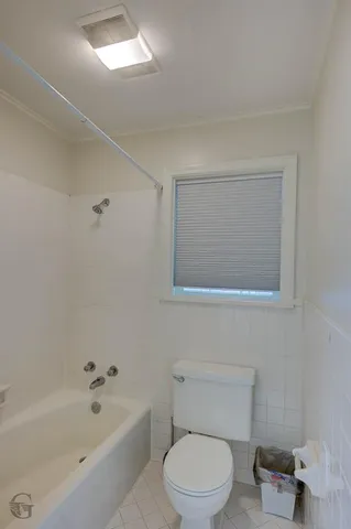 a white toilet sitting next to a bath tub