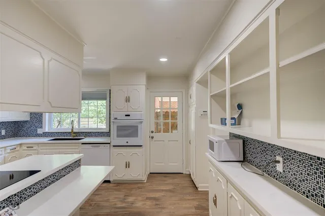 a large kitchen with stainless steel appliances granite countertop a lot of counter space and a sink