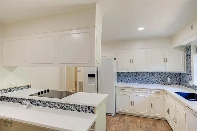 a kitchen with granite countertop white cabinets and white appliances