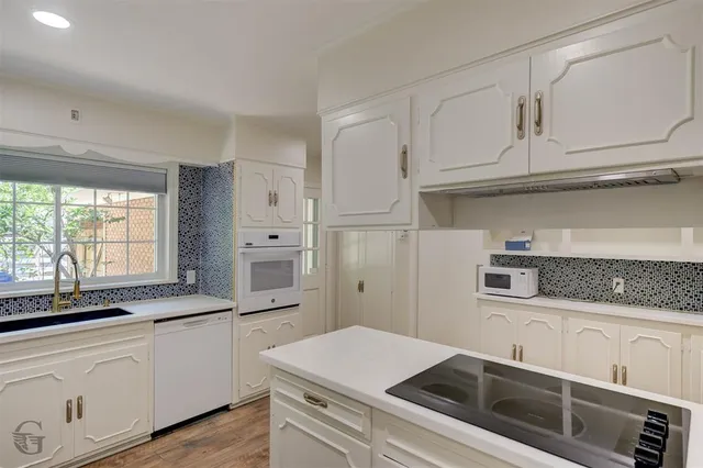 a kitchen with white cabinets and white appliances