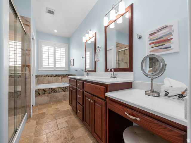 968 South Cyn Road Santaquin, UT 84655 - Photo 11 of 36 Bathroom featuring a double vanity with wood cabinetry and white countertops, a built-in soaking tub with mosaic tile surround, a separate glass-enclosed shower, and stone tile flooring