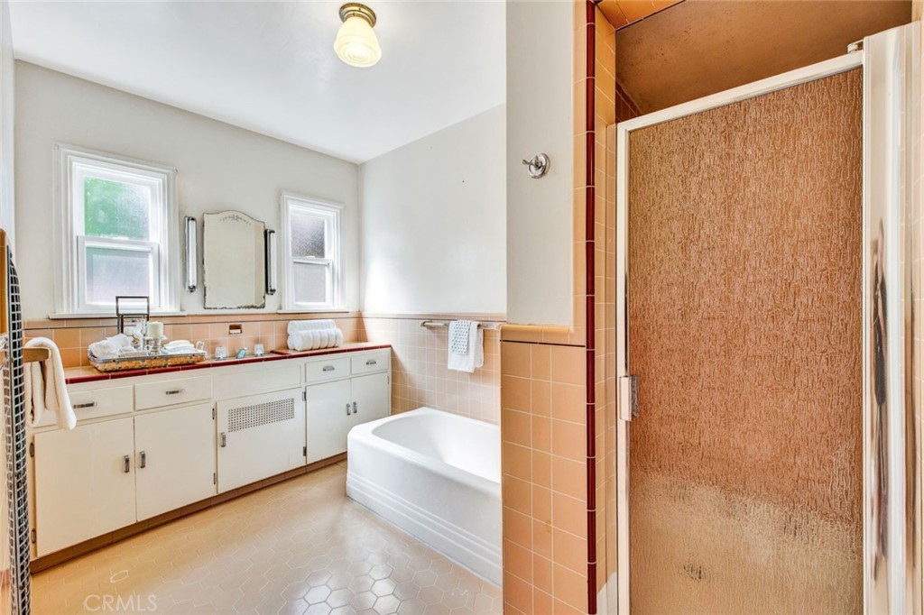 1722 North Flower Street Santa Ana, CA 92706 - Photo 18 of 25 a spacious bathroom with a double vanity sink a mirror and a bathtub